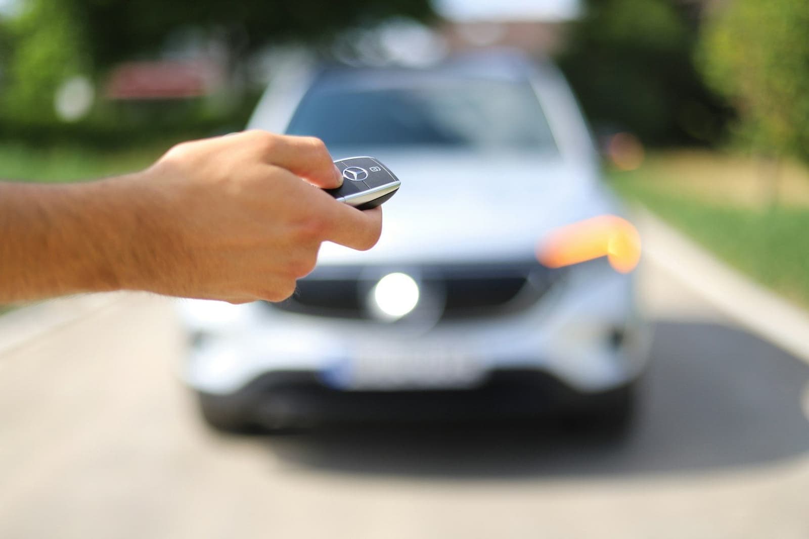 Clé de voiture tendue devant un SUV blanc