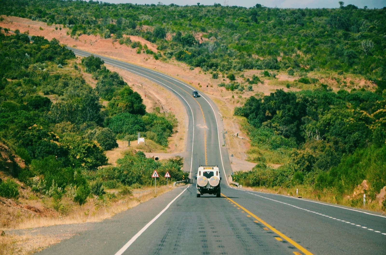 4x4 blanc sur une route entre les collines
